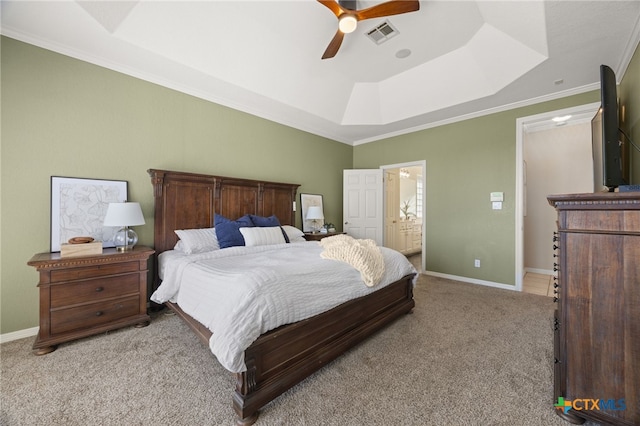 carpeted bedroom with crown molding, ceiling fan, a raised ceiling, and ensuite bath