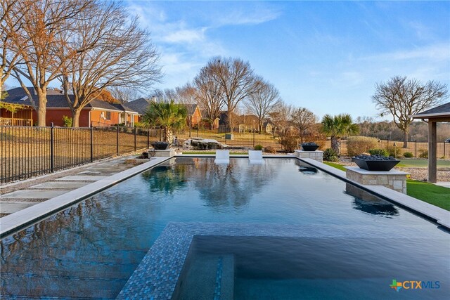 pool at dusk with a gazebo and a patio