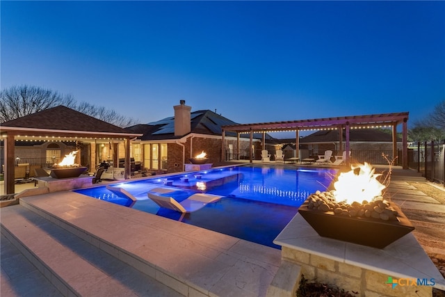 pool at dusk featuring a pergola, a fire pit, a patio, and a gazebo