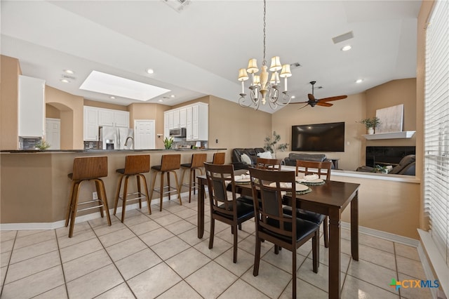 tiled dining space featuring ceiling fan and lofted ceiling