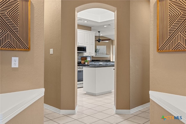 kitchen featuring ceiling fan, light tile patterned flooring, white cabinets, and appliances with stainless steel finishes