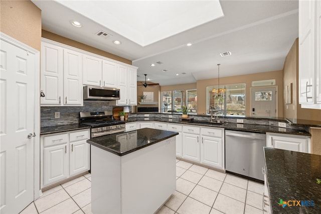 kitchen featuring appliances with stainless steel finishes, white cabinets, and kitchen peninsula