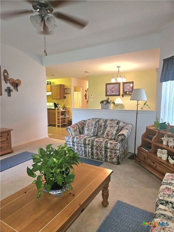 living room with light colored carpet and ceiling fan with notable chandelier