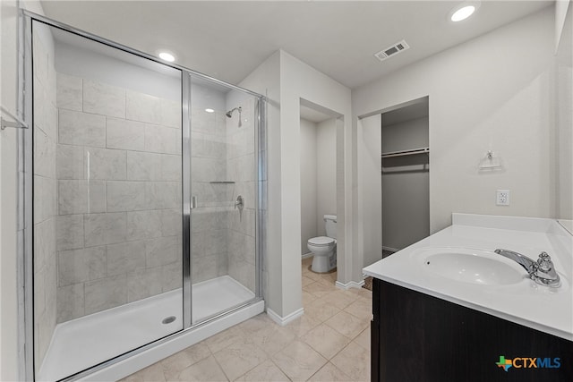 bathroom featuring toilet, vanity, and an enclosed shower