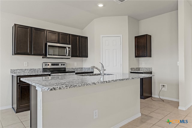 kitchen featuring lofted ceiling, dark brown cabinetry, sink, a kitchen island with sink, and appliances with stainless steel finishes