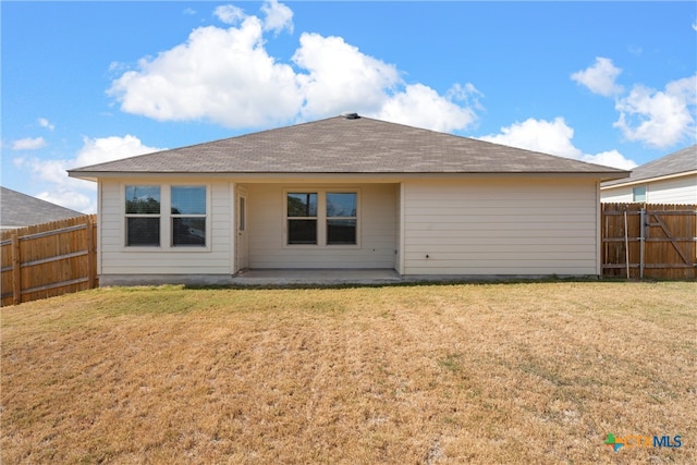 rear view of house with a patio and a yard