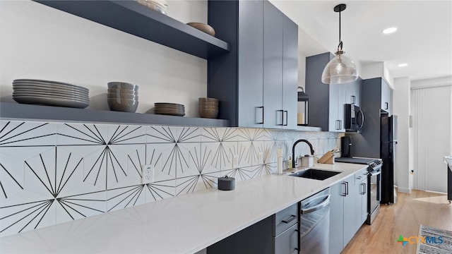 kitchen with sink, hanging light fixtures, backsplash, light hardwood / wood-style floors, and appliances with stainless steel finishes