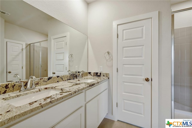 bathroom featuring vanity and a shower with shower door