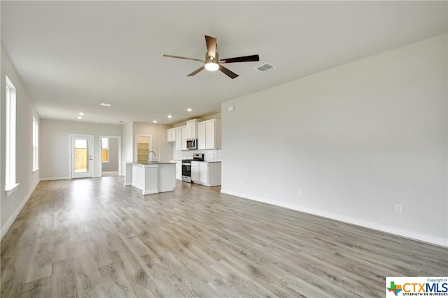 unfurnished living room featuring ceiling fan and light wood-type flooring