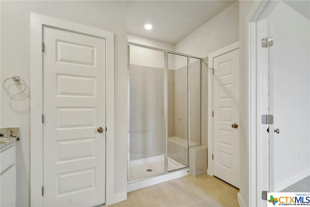 bathroom with an enclosed shower, vanity, and tile patterned floors