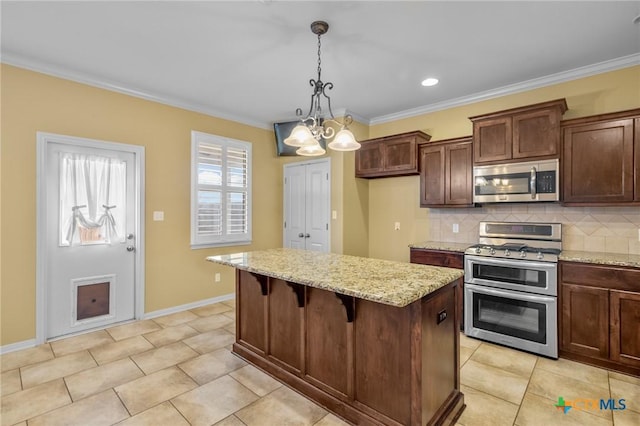 kitchen featuring decorative light fixtures, a kitchen bar, a center island, light stone counters, and stainless steel appliances