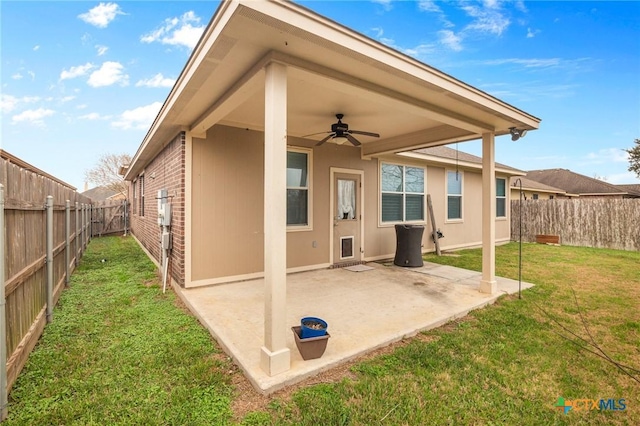 back of house with a yard, a patio area, and ceiling fan