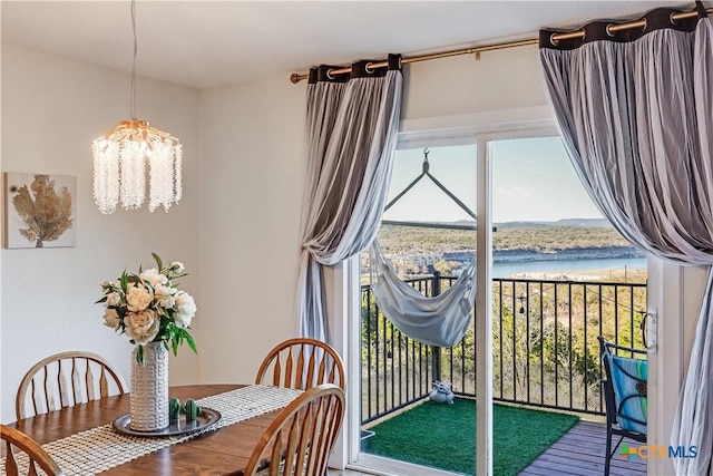 dining space featuring a notable chandelier, a water view, and a wealth of natural light