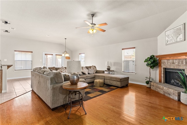 living room with hardwood / wood-style flooring, plenty of natural light, lofted ceiling, and ceiling fan with notable chandelier