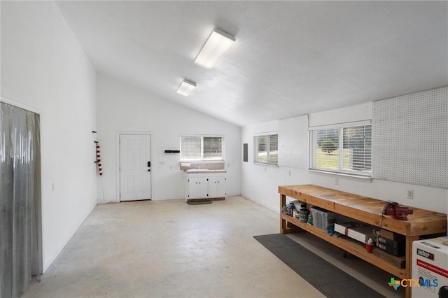 misc room featuring a workshop area, finished concrete flooring, and vaulted ceiling