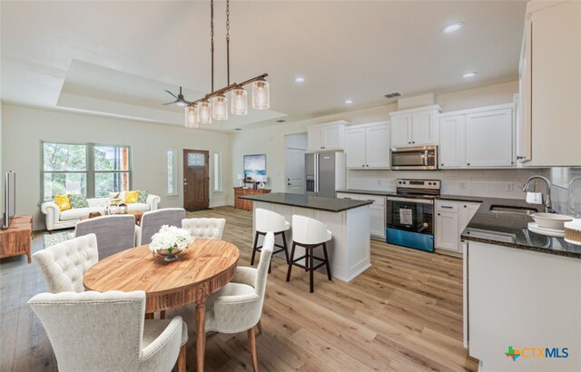 dining area featuring light hardwood / wood-style floors, sink, and ceiling fan