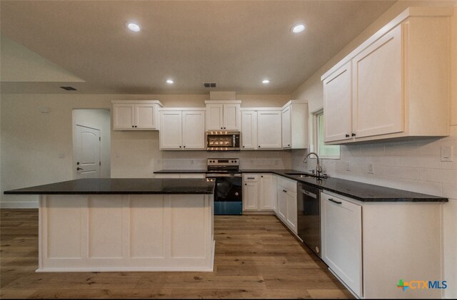 kitchen featuring appliances with stainless steel finishes, sink, light hardwood / wood-style floors, and white cabinets