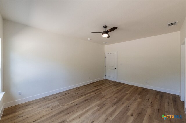 spare room with hardwood / wood-style floors and ceiling fan