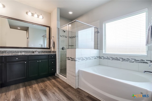 bathroom with hardwood / wood-style floors, vanity, and shower with separate bathtub