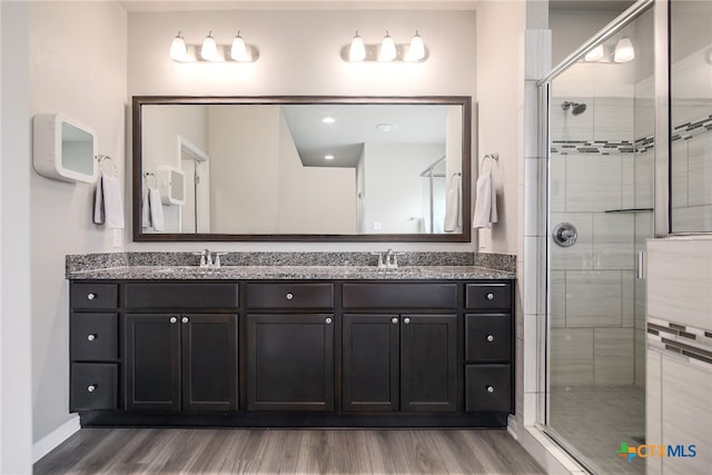 bathroom featuring vanity, wood-type flooring, and walk in shower