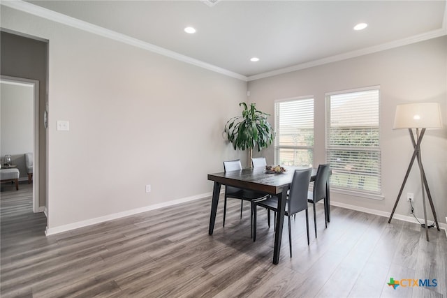 dining space with dark hardwood / wood-style flooring and crown molding