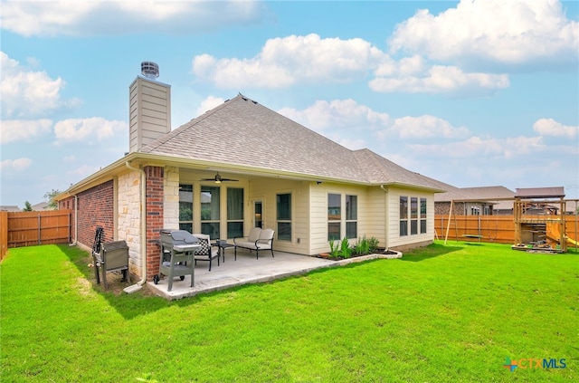 back of property with a patio area, ceiling fan, and a yard