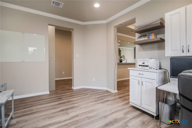 kitchen featuring light hardwood / wood-style flooring, white cabinetry, and crown molding