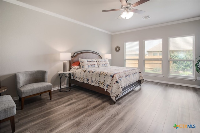 bedroom featuring hardwood / wood-style floors, ceiling fan, and ornamental molding