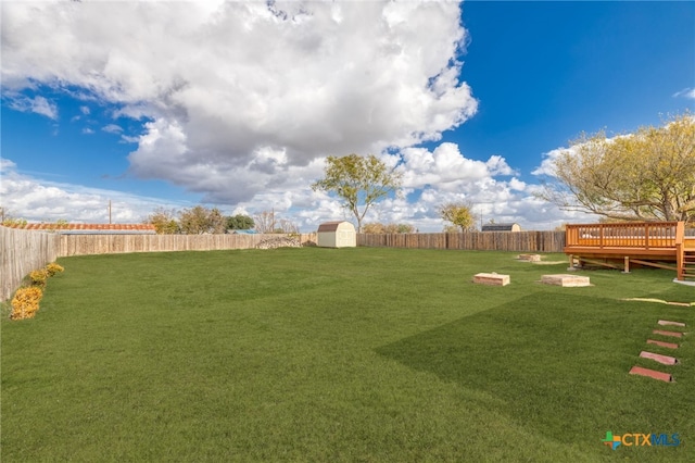 view of yard with a storage unit and a wooden deck