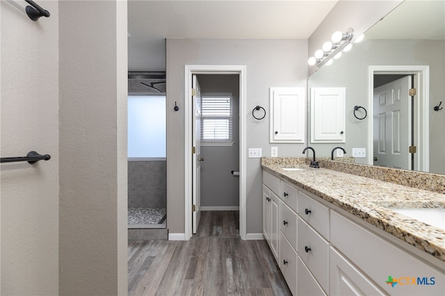 bathroom featuring a shower, hardwood / wood-style floors, and vanity