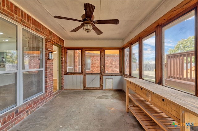 unfurnished sunroom featuring ceiling fan