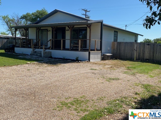 view of front of house featuring fence, a front yard, and a sunroom