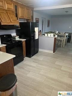 319 W Village Rd, Salado, TX 76571 - kitchen featuring black appliances, brown cabinets, premium range hood, light countertops, and glass insert cabinets