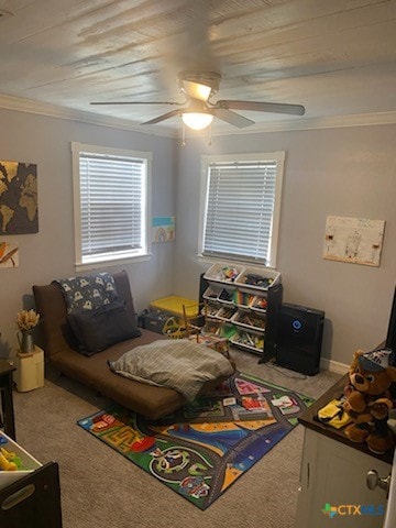 recreation room featuring ceiling fan, ornamental molding, and carpet