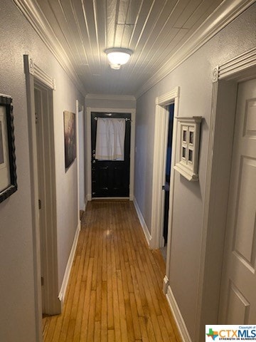 hallway featuring light hardwood / wood-style flooring and crown molding