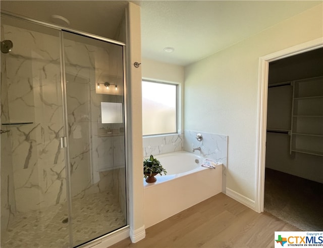 bathroom with hardwood / wood-style floors and shower with separate bathtub