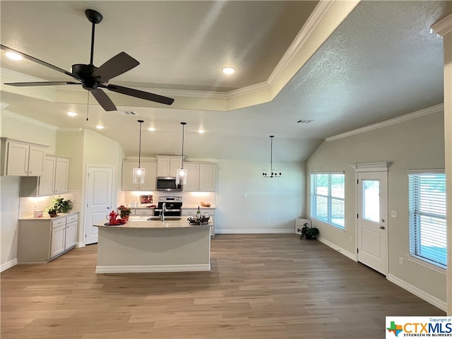 kitchen featuring sink, ornamental molding, a kitchen island with sink, white cabinets, and light wood-type flooring