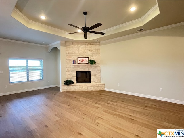 unfurnished living room featuring hardwood / wood-style floors, a raised ceiling, and crown molding