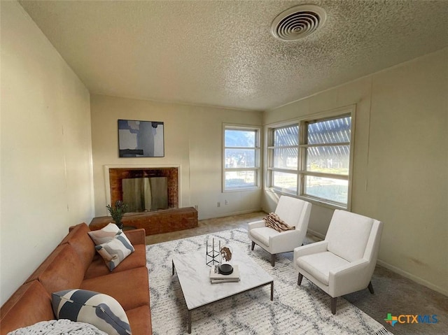 living room with carpet, a fireplace, and a textured ceiling