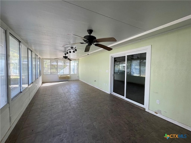 unfurnished sunroom with ceiling fan