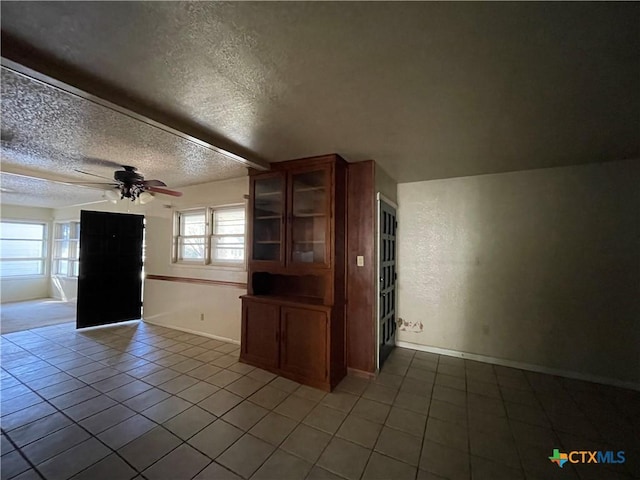 interior space featuring tile patterned floors, ceiling fan, and a textured ceiling