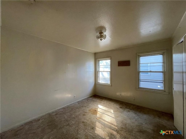 empty room with carpet and a textured ceiling