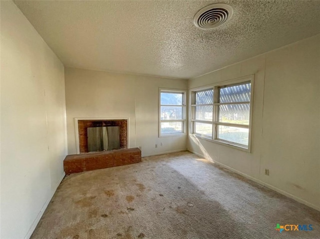 unfurnished living room with carpet, a textured ceiling, and a fireplace