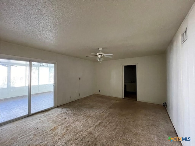 carpeted empty room featuring ceiling fan and a textured ceiling