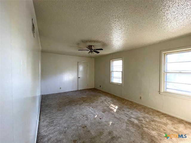 unfurnished room with ceiling fan, carpet, and a textured ceiling