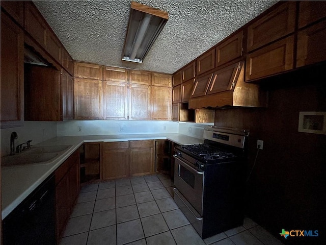 kitchen with dishwasher, sink, stainless steel gas range oven, a textured ceiling, and light tile patterned floors