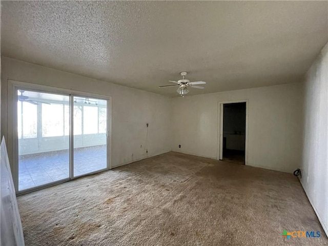 carpeted empty room featuring a textured ceiling and ceiling fan