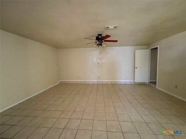 tiled spare room featuring ceiling fan