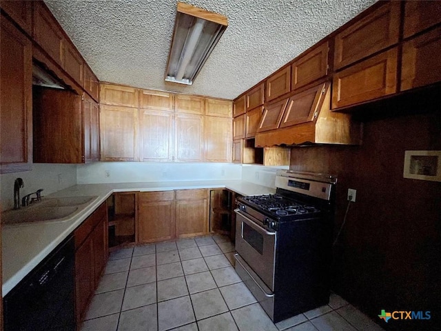 kitchen with gas range, dishwasher, sink, a textured ceiling, and light tile patterned floors