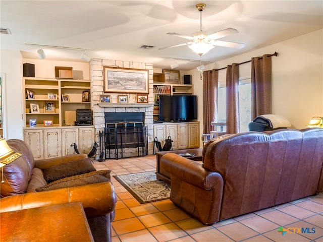 living room featuring a fireplace, rail lighting, ceiling fan, and light tile patterned flooring